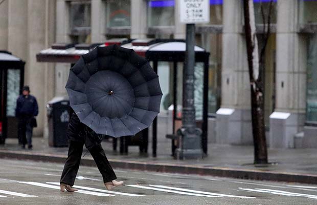 A woman walks in the rain in downtown Seattle on Tuesday, Dec. 8, 2015. The National Weather Service has issued a flood watch for much of Western Washington, as well as high wind warnings for the coast and other areas. (Greg Gilbert/The Seattle Times via AP) SEATTLE OUT; USA TODAY OUT; MAGS OUT; TELEVISION OUT; NO SALES; MANDATORY CREDIT TO BOTH THE SEATTLE TIMES AND THE PHOTOGRAPHER