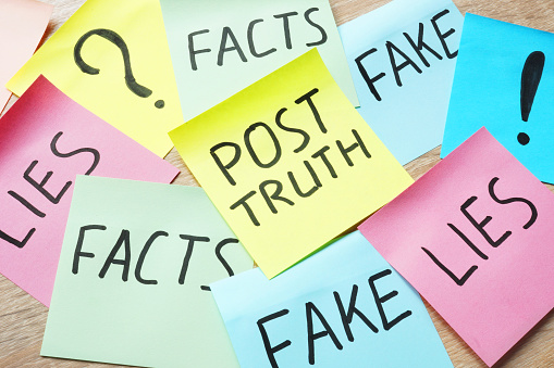 Memo stick with words Post-truth and lies, fakes and facts.