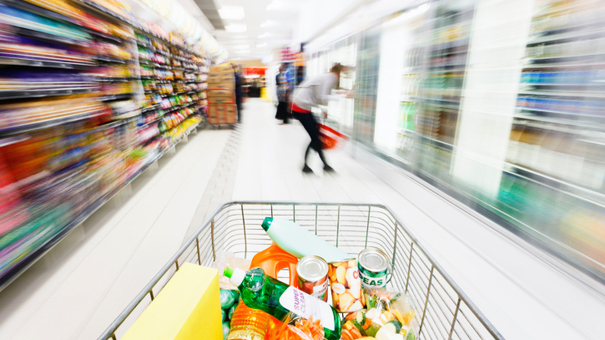 Looking over shopping cart at motion-blurred supermarket aisle